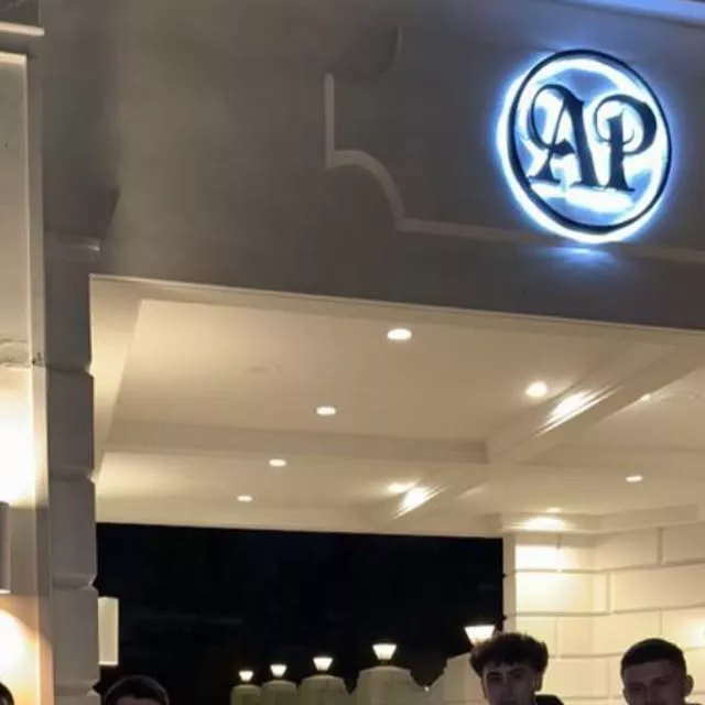 Premier Valet attendants outside the lit entrance of Addison Park at night