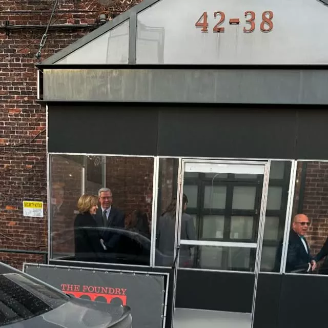Guests inside the glass entrance of The Foundry at 42-38, with a Foundry banner out front