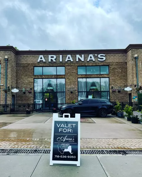 Premier Valet sign reading Valet for: Ariana's South in front of a brick building marked Ariana's