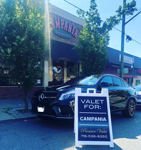 Black Mercedes SUV parked outside Campania Coal Fired Pizza beside a Premier Valet sign