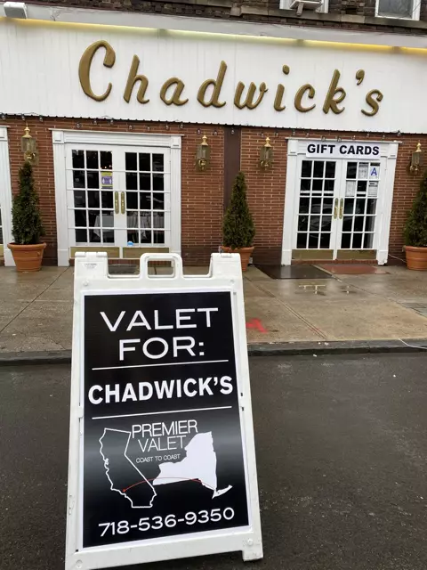 Premier Valet sign reading Valet For: Chadwick's on the street outside Chadwick's brick storefront