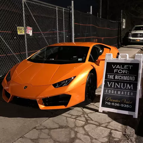 Orange Lamborghini at night beside a Premier Valet sign reading Valet For: The Richmond, Vinum, Edgewater