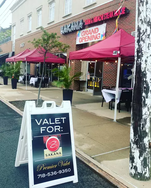 Premier Valet A-frame sign reading Valet For: Sakana outside a restaurant with red canopy tents